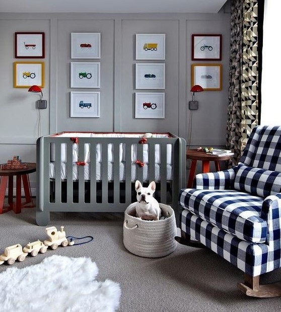 a lovely grey nurseyr with a grey crib, a plaid rocker chair, layered rugs, a bold gallery wall and a basket with toys