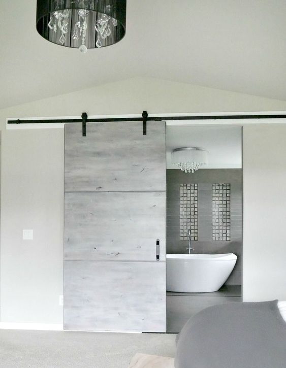 a modern grey sliding barn door for an ultra-modern space brings a rustic feel yet with a modern twist