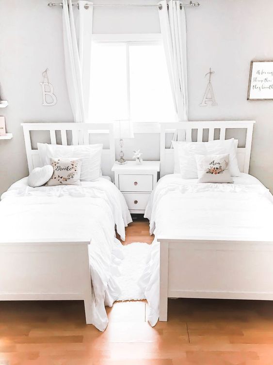 a neutral shared girls' bedroom with white beds and a nightstand, white curtains and bedding is a very airy and dreamy idea a neutral shared girls' bedroom with white beds and a nightstand, white curtains and bedding is a very airy and dreamy idea