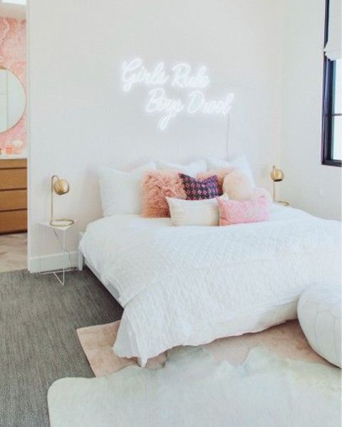 a playful modern teen girl bedroom with a comfy bed, a neon light, touches of brass and layered rugs
