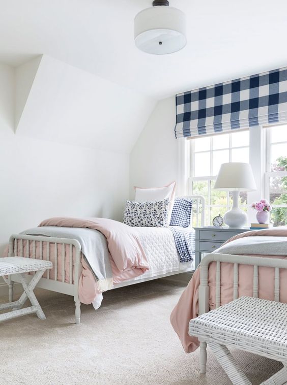 a preppy shared girls' bedroom with white vintage furniture, a checked curtain and pastel and gingham printed bedding