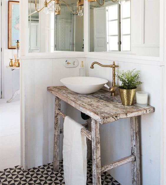 a shabby chic rustic wooden sink stand makes the modern bowl sink and a chic brass faucet look more balanced and cool