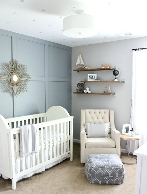 a slate blue and grey nursery with chic white furniture, open shelves and a ceiling lamp is very chic