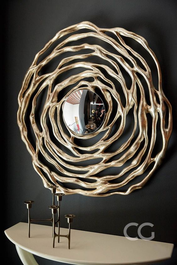 a small round mirror with a unique gold frame that resembles a flower is a lovely and catchy art-inspired idea for a modern room