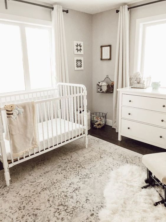 a stylish gender neutral nursery with grey walls, white vintage furniture, some art and toys that match