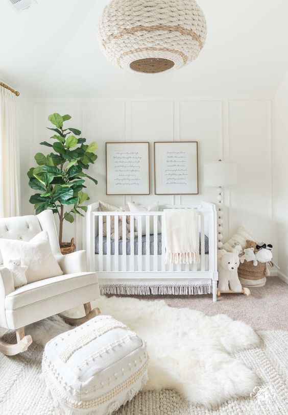 a welcoming white nursery with a wicker lampshade, a knit and fur rug, a white chair and baskets for storage