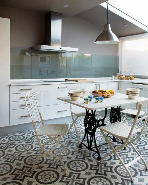 an attic kitchen with lower white cabinets, grey walls and a green glass backsplash for a subtle touch of color