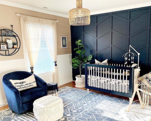 an elegant nursery with a black 3D geometry accent wall, a matching crib and a navy chair to create a cohesive look