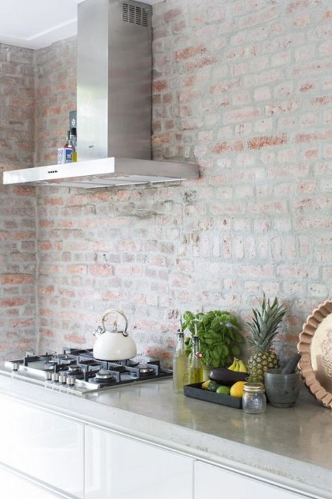 a modern white kitchen with a whitewashed red brick wall, not just a backsplash for a textural touch