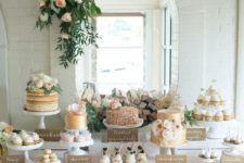 a tender blush dessert table with a large scale sequin tablecloth, a lush greenery and bloom decoration and lots of desserts