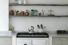 a white brick wall adds texture to the space and matches the neutral kitchen decor at the same time