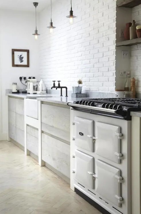 a white brick wall perfectly matches the Nordic kitchen and adds texture and interest to it
