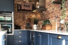 blue kitchen cabinets with white countertops and red brick walls is a bold contrasting idea with a touch of chic