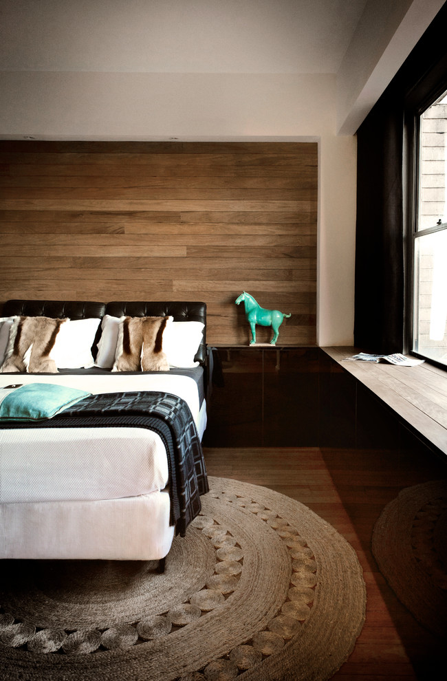 a dark leather headboard looks great against a wall covered with wood panels (Darren Palmer Interiors)