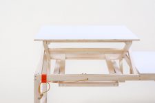 01 This adjus.table is made of light-colored wood and can be regulated manually