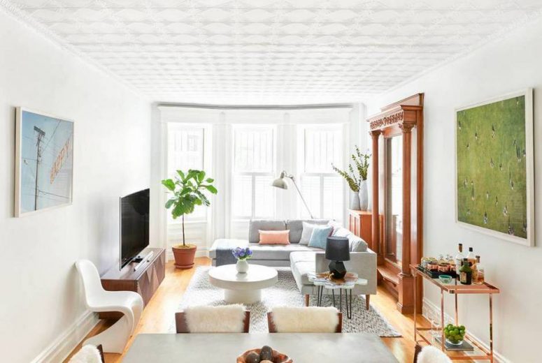 The mirror reflects the light coming from the big windows and makes the room look bigger