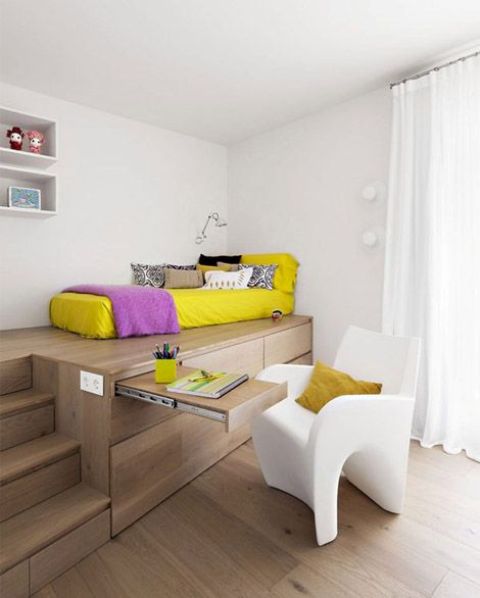 bed placed on a wooden podium to separate it from the rest of the room and provide additional storage space