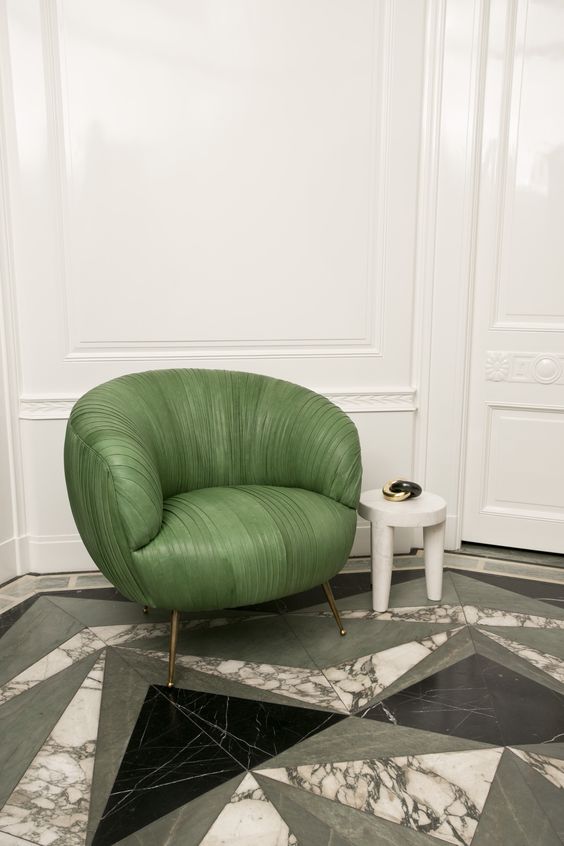 geometric marble floors and a statement green leather chair