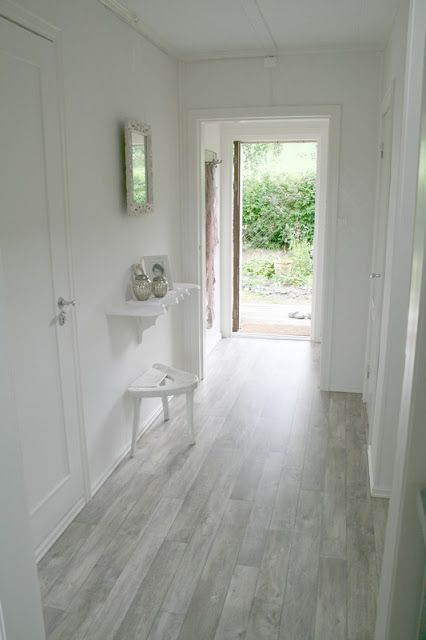 grey floors in the white hallway definitely give a light feeling to the room