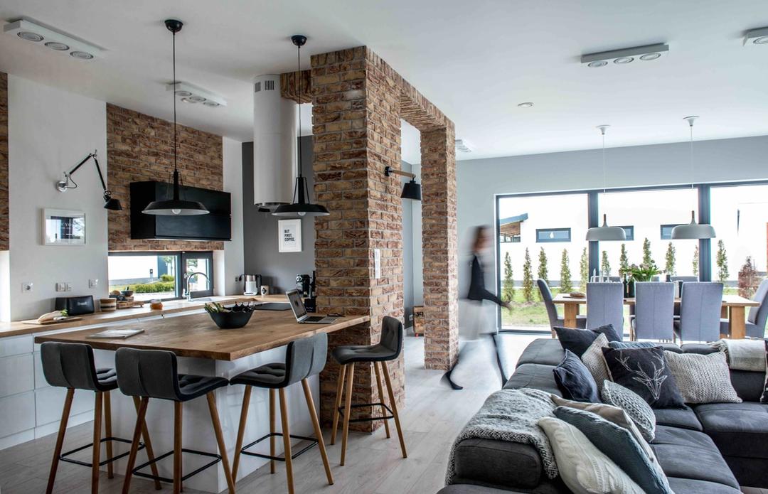 The kitchen island with a built-in cooker and dishwasher doubles as a worktop