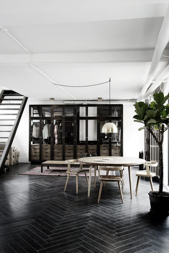 black wood floors clad with a herringbone pattern mixed with dark cabinets