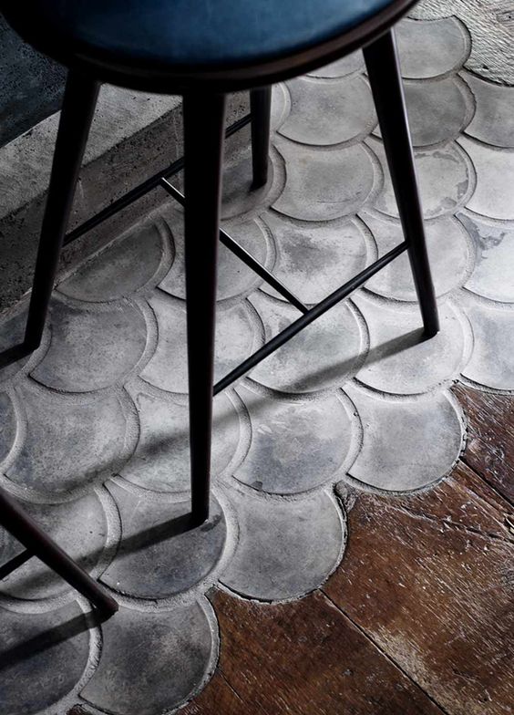 Fish scale scallops in concrete mingle with wood flooring