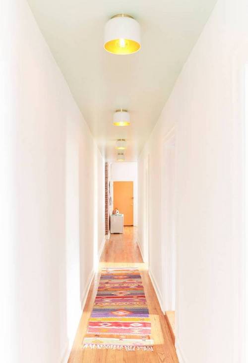 The corridor ceiling is softly mint with cool gilded lamps