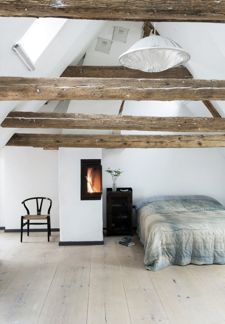 07 The master bedroom is an attic space with exposed wooden beams a wood hearth and Dinesen oak floors very peaceful and relaxing 775x1117