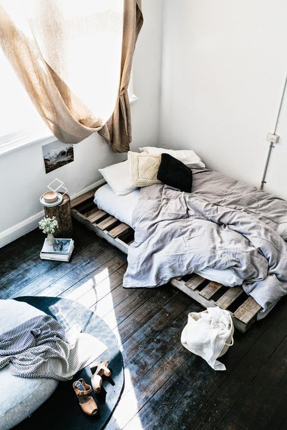 dark shabby hardwood floors are in the center of attention in this simple bedroom