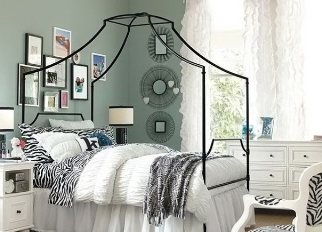 large canopy bed without draperies helps to divide the space