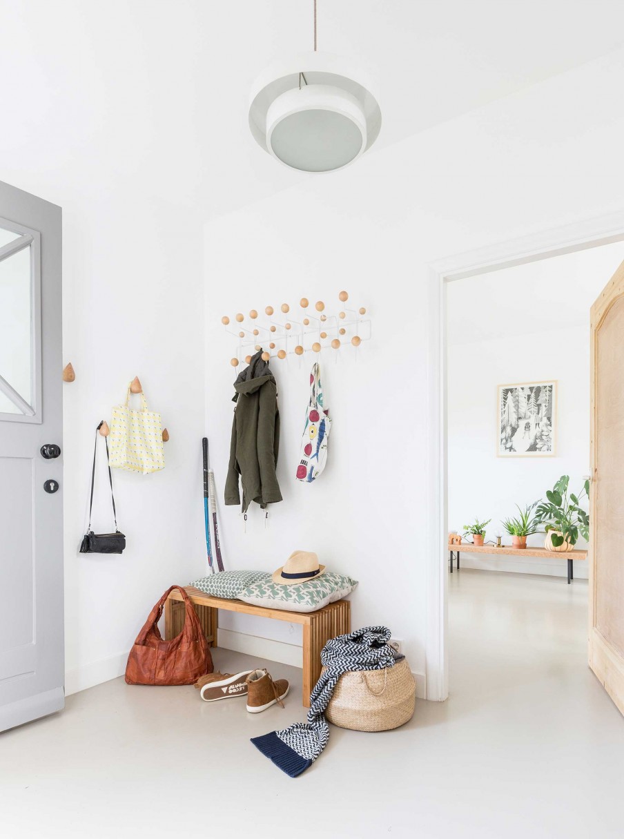 The entryway is Scandinavian, all-white with light-colored wood touches