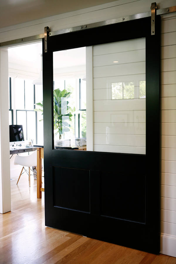 The home office is hidden behind a lsiding barn door