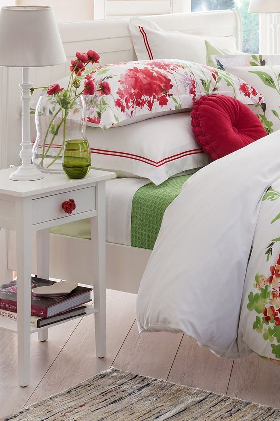 White bedroom is dotted with touches of red and green