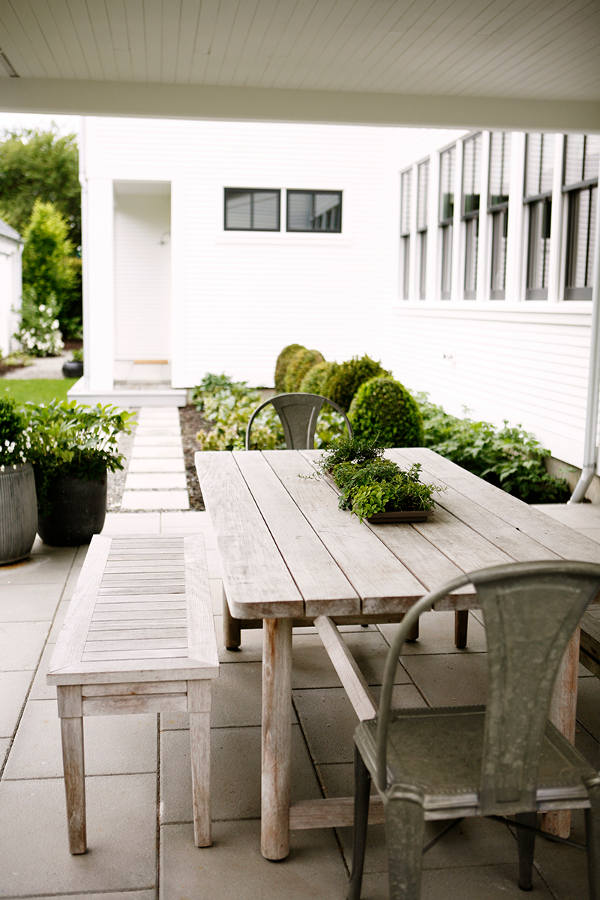 The outdoor eating area is decorated with rustic whitewashed furniture