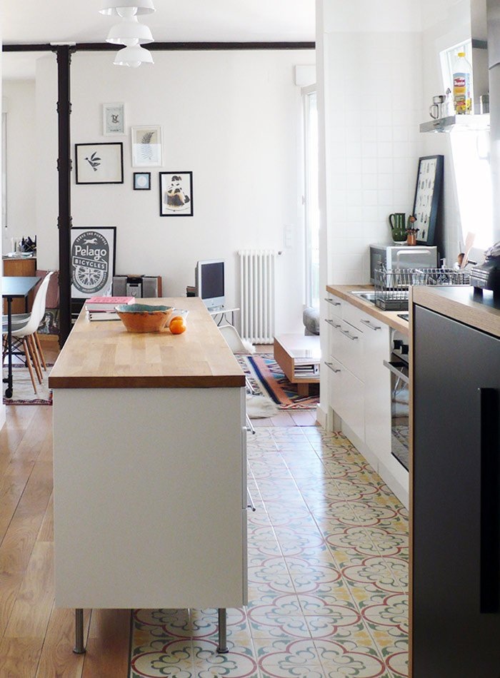 Поднятый кухонный остров в этом доме перекрывает разрыв между кухонной плиткой и древесиной.
