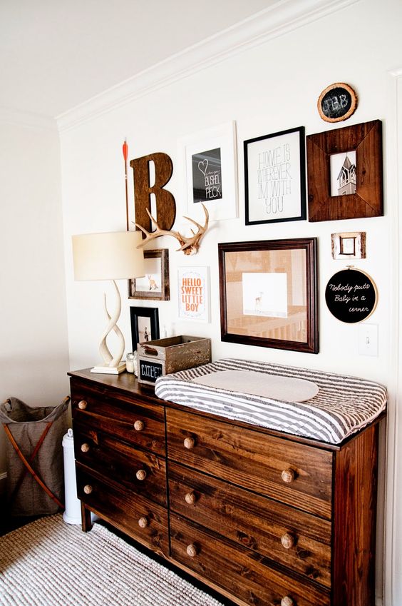 rustic nursery gallery wall and changing table with a lot of drawers