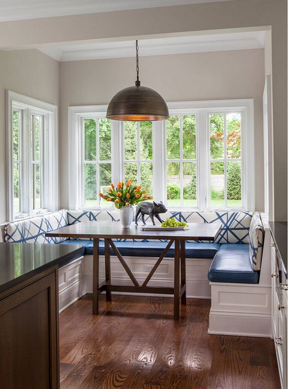 blue and white breakfast zone with a dark table and a dark pendant light fixture