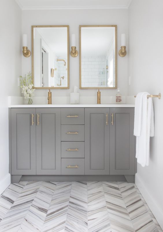 ceramic grey floor tiles clad in a herringbone pattern