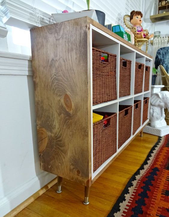 a Kallax shelf renovated with MDF for a more rustic and cozy feel, with kids' toys storage and some decor on top