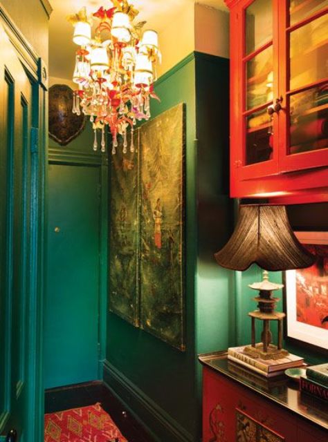 Emerald-green and red paint give the entryway a moody feel