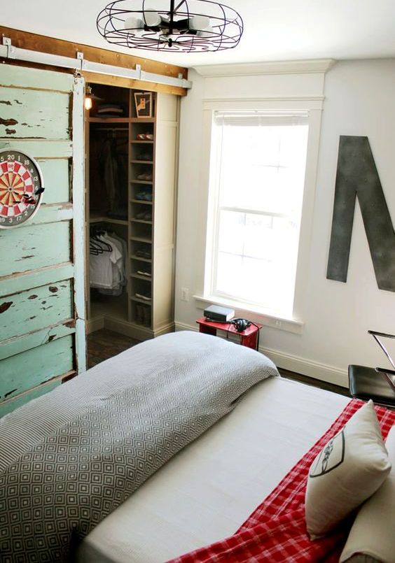 23 a closet in a bedroom behind sliding barnwood doors