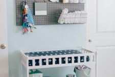 25 modern white changing table with a pegboard over it for storage