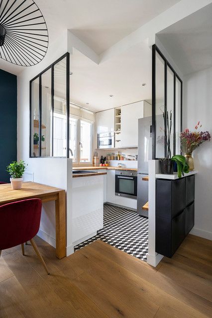 a catchy modern white kitchen with upper and lower cabinets, a black and white tile floor and a wooden one is a stylish idea