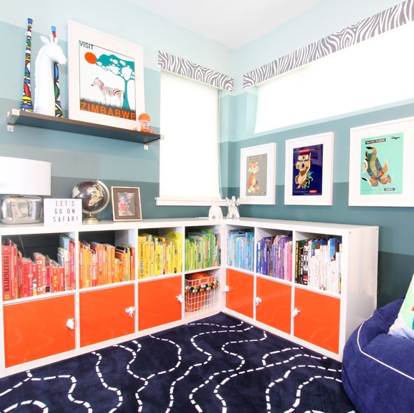 a corner shelving unit made of IKEA Kallax, with bold orange doors and colorful books to create a gradient effect