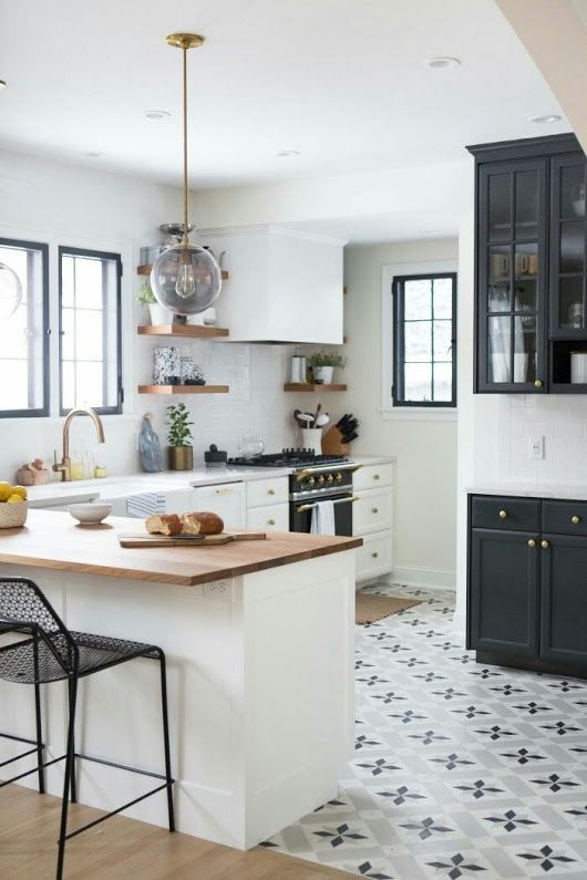 a modern white kitchen with neutral and butcherblock countertops, a tiled floor and laminate, stained shelves