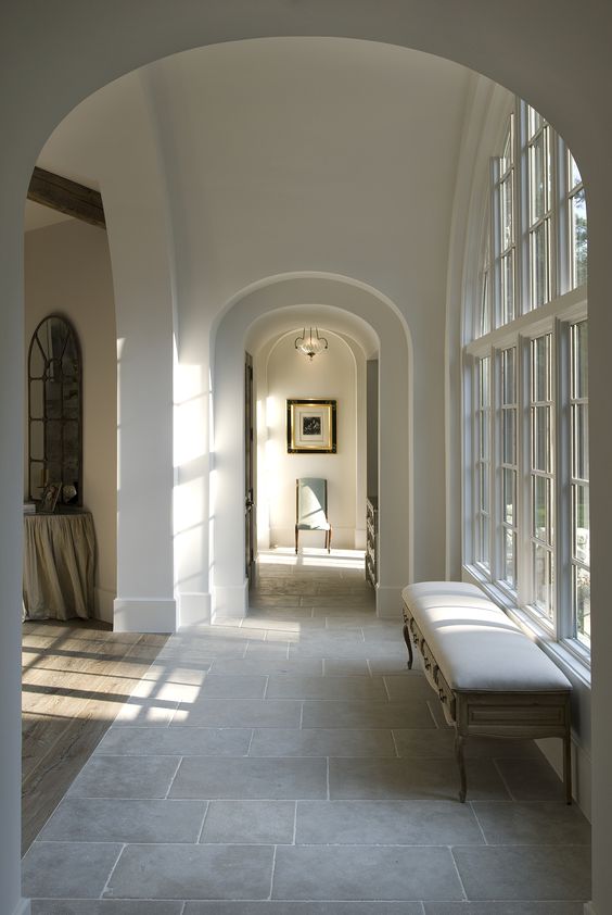 a refined space with arched doorways and a floor transition from tiles to laminate is a very cool and cozy idea