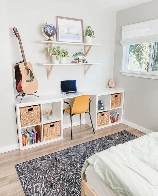 a storage desk composed of two IKEA Kallax pieces finished with woven drawers and some decor plus a yellow chairs is a cool idea for a kid's room