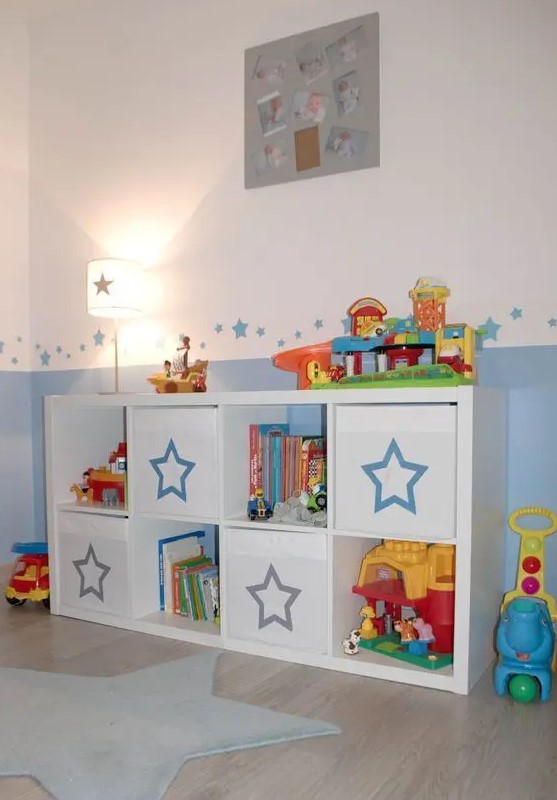 an IKEA Kallax shelf with Drona boxes finished with pretty stars is a lovely idea for a kids' room, it will provide you with storage