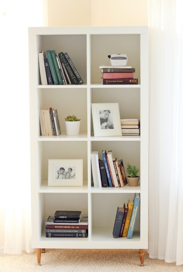an IKEA Kallax unit turned into a bookshelf, with stained legs and pretty decor is a lovely idea