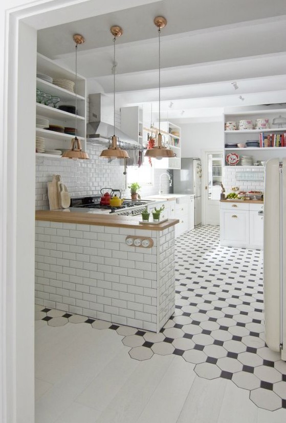 black and white mosaic tiles in the kitchen, whitewashed laminate in the rest of the space